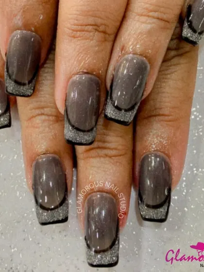 A moody and glamorous French manicure. We used a glossy, deep brown base and added a sparkling silver glitter French tip, outlined with a thin black line for a sharp, sophisticated finish.