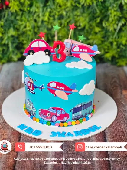 A vibrant transportation-themed cake for Shardul's 3rd birthday. It's covered in cars, planes, and helicopters, perfect for a little one who loves all things that go.