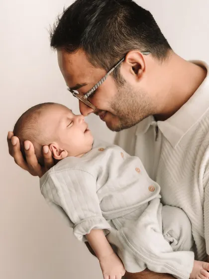 A father's tender moment with his newborn, nose-to-nose, showing the instant bond.