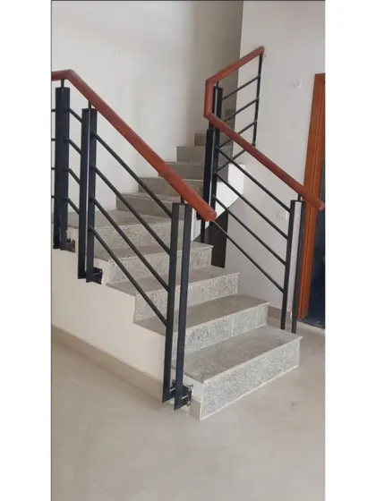 **BEFORE:** The original staircase with bulky black railings and granite steps, which felt dated and heavy.
