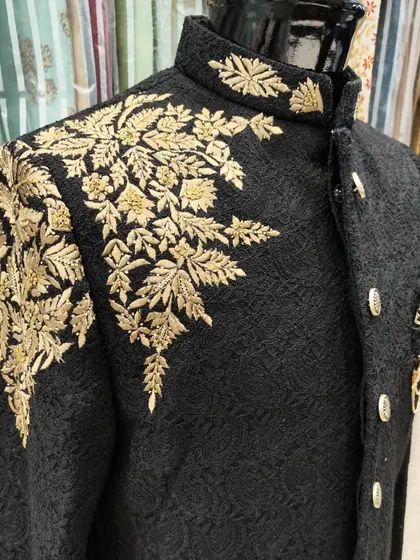 Another view of the black Jodhpuri suit with gold leaf embroidery, showing the beautiful texture of the fabric.