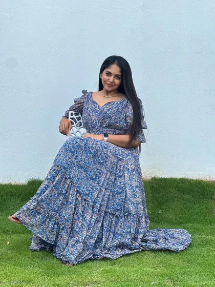 A client looking lovely in a blue floral tiered maxi dress, perfect for a casual event or a day out.