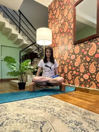 Lifting up on blocks with legs crossed, a strength drill for arm balances.