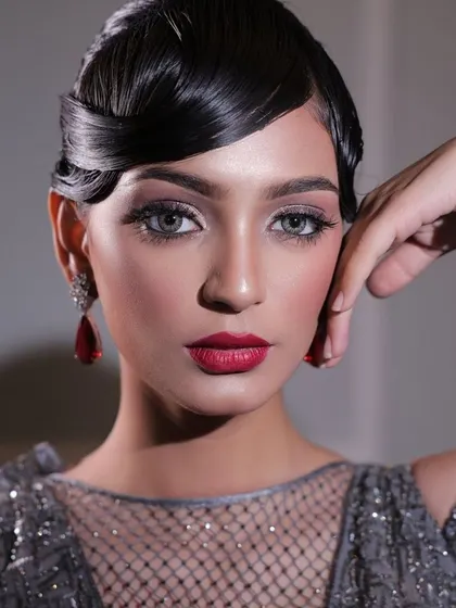 Unleashing the glam with bold eyes and glowing skin. This look, with its vintage-inspired hair and dramatic red lip, is all about confidence, elegance, and unstoppable beauty.