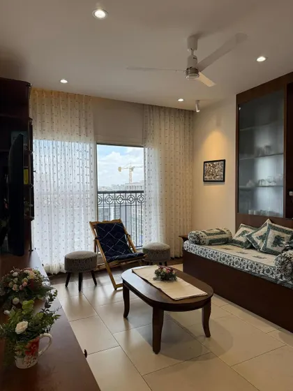 Some spaces scream luxury. This one prefers polite sarcasm and a second cup of chai. A cozy, lived-in living room with classic wooden furniture.