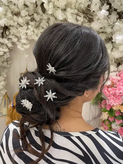 A classic Western-style low bun, perfect for a reception gown or a Christian wedding. The sparkling star accessories add a touch of whimsy and glamour.