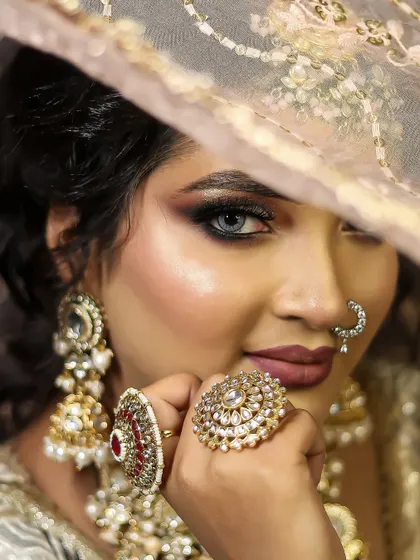 Mastering the art of the classic bridal look. This is a demonstration of a flawless, soft-glam bridal makeup, focusing on a radiant base, subtle smokey eyes, and elegant jewelry placement, a core skill in our curriculum.