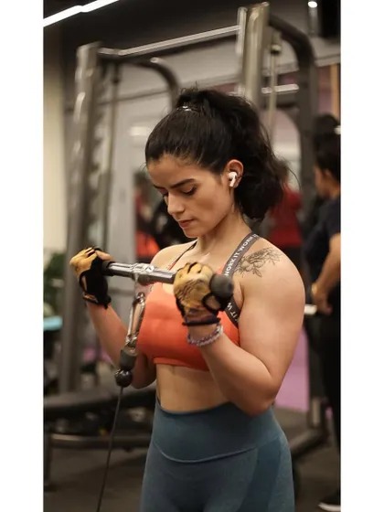 This client is using the cable machine to perform bicep curls, which provides constant tension on the muscle for a great workout.