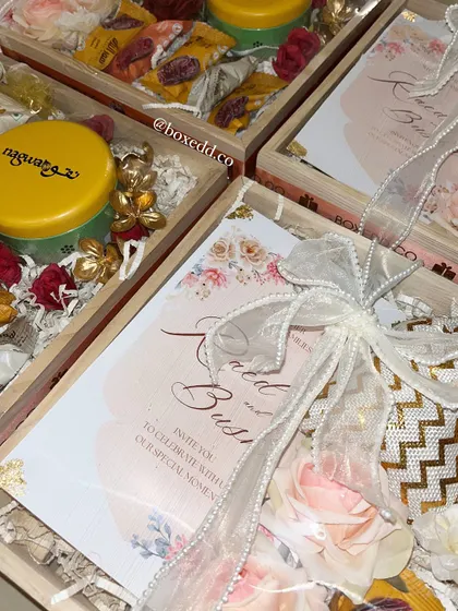 A close-up of our wedding invitation trays. This view highlights the floral printed invitation card, the elegant ribbon, and the carefully selected gourmet treats that accompany it.