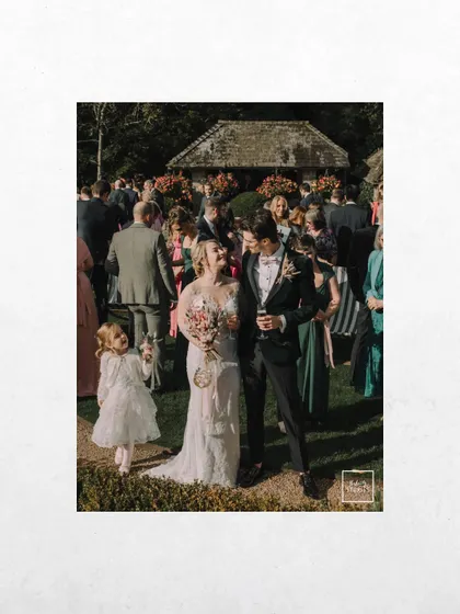A candid shot of the couple walking through their guests, with a little flower girl looking on. It’s a beautiful, unscripted moment full of life.