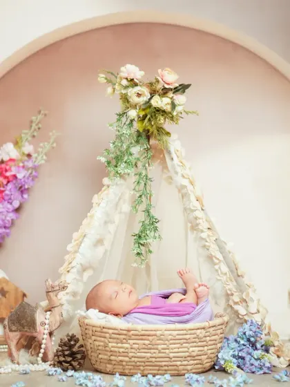This teepee setup, adorned with delicate flowers, creates a beautiful bohemian vibe for a newborn session. It’s all about creating a peaceful and artistic portrait of your sleeping baby.