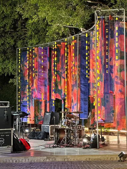 A colorful stage backdrop made of printed organza drapes, ready for a live band performance during a Mehendi or Sangeet.