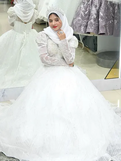 A bride seated in her magnificent ball gown, the skirt pooling around her. The mirror reflection shows just how much detail and craftsmanship went into this creation.