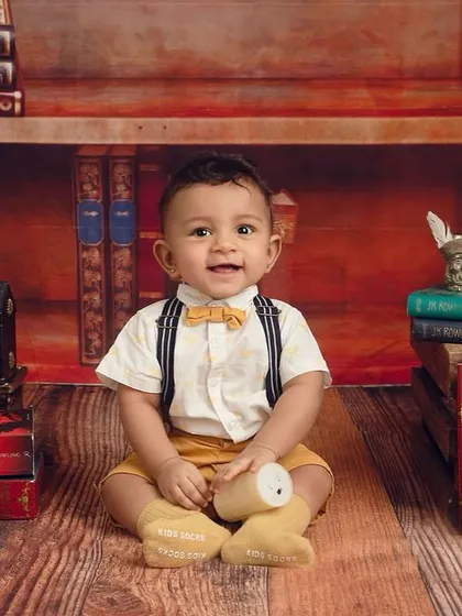 A full smile from our little wizard. The warm lighting and rich colors of the backdrop make this portrait feel extra magical.