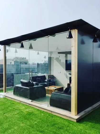 A daytime view highlighting the sleek design of our glass room. The black ACP paneling combined with floor-to-ceiling glass offers a modern, minimalist aesthetic that complements any urban environment.