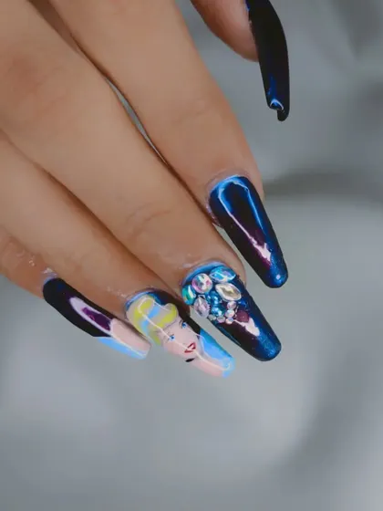 A close-up of my hand-painted Cinderella nail set. This design features a portrait of Cinderella, a sparkling blue chrome nail, and a nail fully encrusted with iridescent rhinestones.