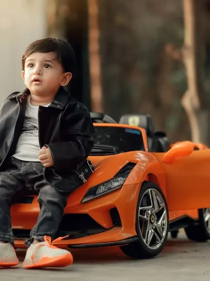 A cool and casual pose from a little car enthusiast. The natural outdoor lighting and his relaxed attitude make this a great portrait.