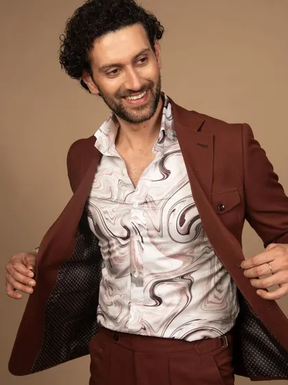 Elevate your safari style with this rust suit. The unique printed shirt underneath adds a touch of personality, creating a look where rugged meets refined.