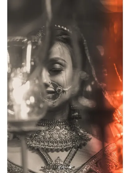 An artistic, blurry shot of a bride holding a lamp, with a mix of black and white and color.