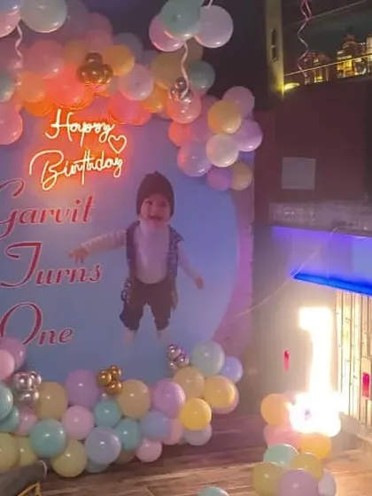 A Boss Baby theme for Garvit's first birthday party in a restaurant. The setup includes a custom backdrop, character cutouts, and a pastel balloon arch, perfect for the little boss.