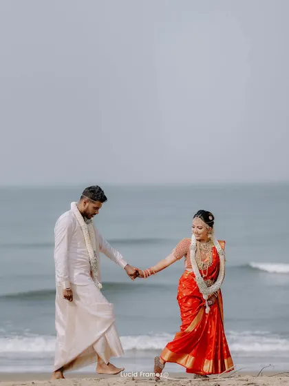 A playful moment on the shoreline, capturing their joy and the beauty of a Kerala beach wedding.