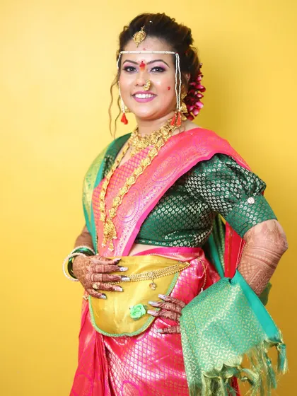 Bringing tradition to life with expert artistry. This Maharashtrian bride looks stunning in her pink and green saree, with makeup that perfectly matches the festive occasion.
