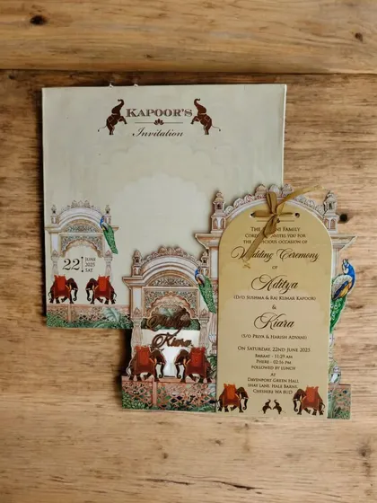 This majestic Rajputana-themed MDF laser-cut invitation features a royal procession with elephants and peacocks. The multi-layered design creates a beautiful 3D effect.