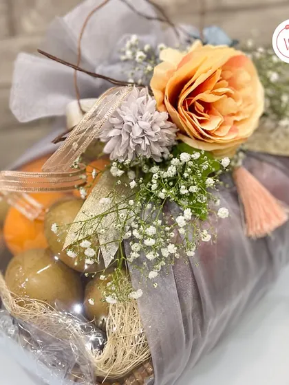 Another view of the fruit basket, showing the variety of fresh fruits like kiwis and oranges included.