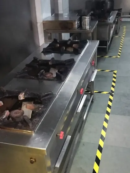 A close-up of our commercial-grade gas stove ranges. The kitchen is equipped with multiple burners to handle cooking for large-volume orders simultaneously.