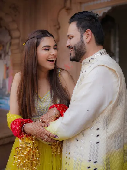 A candid shot of the couple sharing a laugh during their Haldi, capturing the genuine joy and connection between them.
