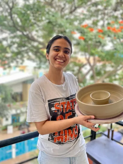 A student proudly holding her chip-and-dip bowl, one of the many pieces she created during her course.