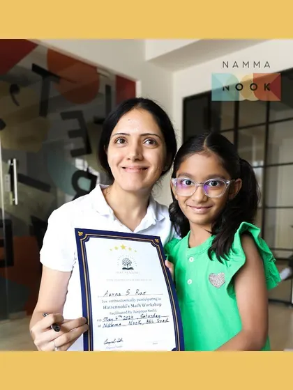 A proud moment with a young participant holding her certificate after a math workshop. Celebrating achievements, big and small, is key to building a child's confidence.