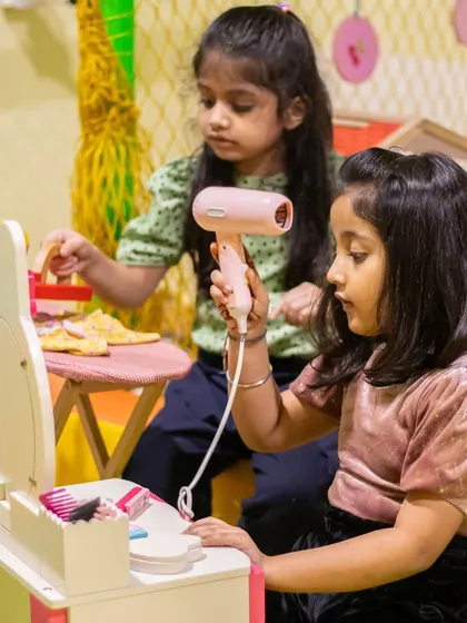 Getting glammed up at our mini vanity station. This corner is perfect for imaginative role-playing and creative fun.