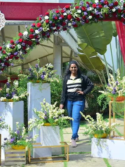 Here I am at a resort wedding we planned. This photo booth with a floral arch was a huge hit with the guests.