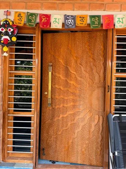 A welcoming entrance sets the tone for the entire home. We designed and commissioned this custom sun-carved wooden main door to add a personal and artistic touch right from the doorstep of this farmhouse project.