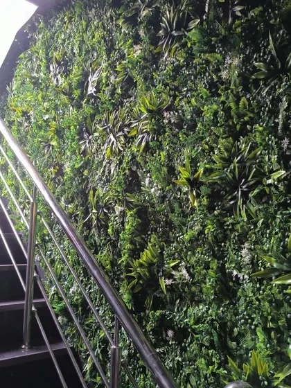 This shot shows the scale of the green mat installation at the Corfit gym entrance in Vikaspuri. It covers the entire wall along the staircase, creating a major visual impact.