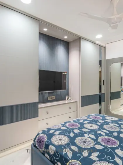 A view of the bedroom showcasing the sliding mirror wardrobe, which adds depth and reflects light, making the room feel more spacious.