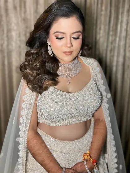 An engagement stunner in all-white. The makeup features soft pinks and a dewy finish to create a dreamy, angelic look.