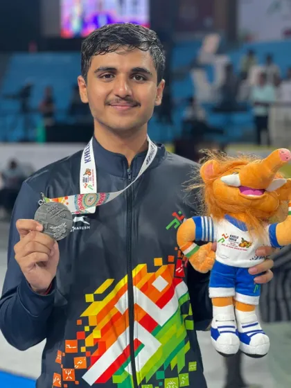 A close up of Rohan Shaha with his silver medal and the Khelo India mascot. This portrait captures the joy and pride of a young athlete who has achieved national success.