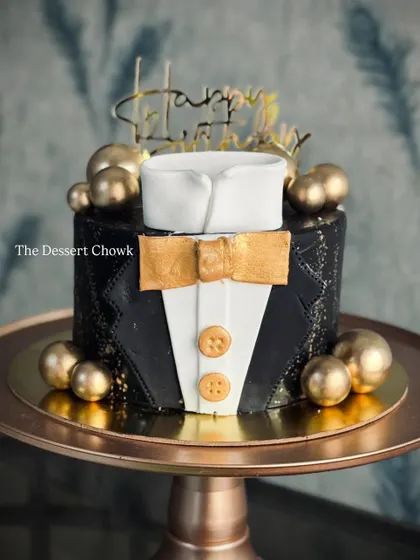 A sharp and stylish tuxedo cake, perfect for the gentleman in your life. This tall chocolate truffle cake is decorated in black and gold for a sophisticated look.