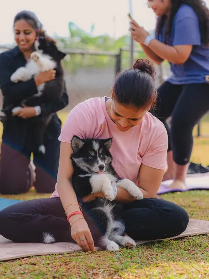 A participant enjoying some quality cuddle time with a puppy during a break in the yoga session.