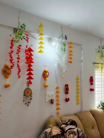 Another angle of the living room decor, showing how the handmade hangings in different colors and shapes create a dynamic and joyful atmosphere.