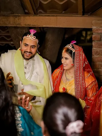 A candid moment as the couple makes their entrance, greeted by family. This shot captures the excitement and traditional welcome that marks the beginning of the wedding ceremony.