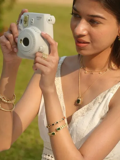 Capturing memories in style. This model, wearing a stack of my emerald and gold bangles and layered necklaces, shows that my jewellery is perfect for every moment.