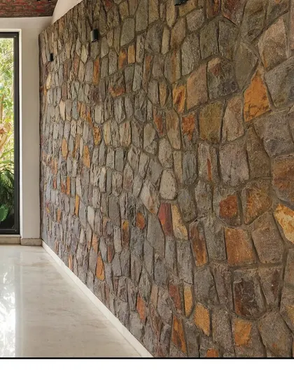 A detail of the random rubble stone wall, showcasing the texture, color, and craftsmanship of this locally sourced material.