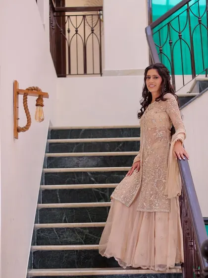 A candid-style shot of the bride-to-be on a staircase. The natural pose and soft lighting create a relaxed and beautiful portrait.