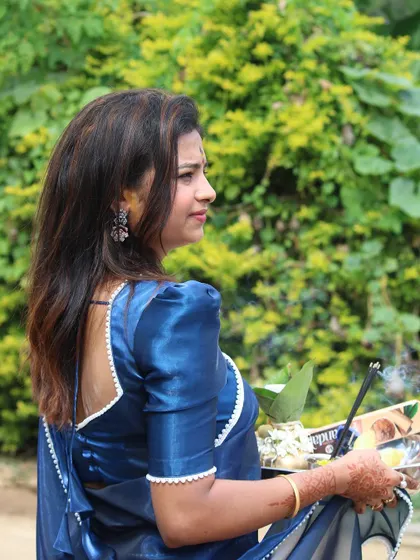A side profile of Sonu, showing the simple yet elegant puff sleeves of her blouse.