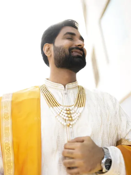 A sun-kissed portrait of the groom, capturing a moment of pure happiness and contentment.