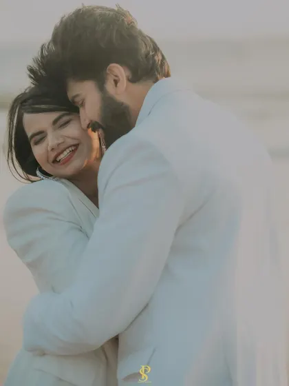A beautiful, happy embrace captured on the beach. This photo is all about genuine emotion and the warmth of the couple's connection, highlighted by the soft, golden light.