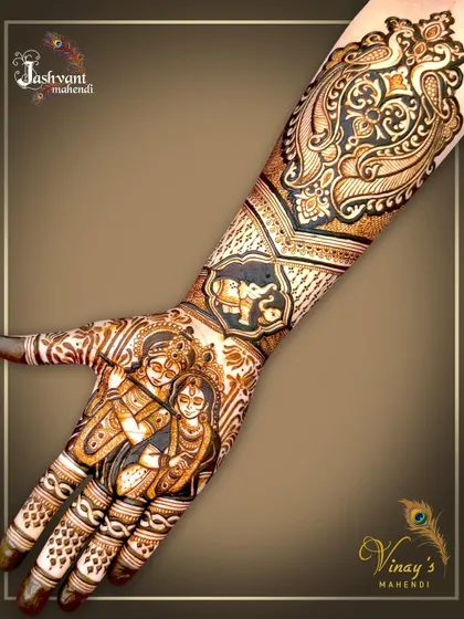 A full-hand view of the Radha Krishna design, showing how the divine portrait on the palm connects seamlessly with the traditional peacock and elephant motifs on the arm.